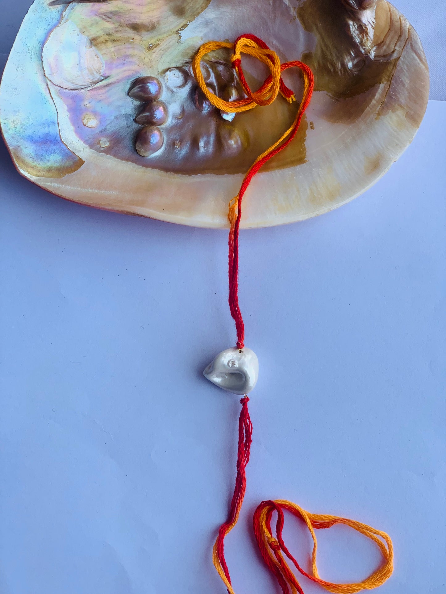 White baroque pearl in mauli thread